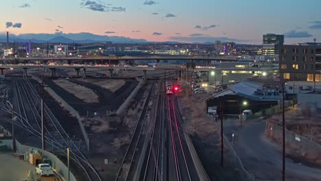 aerial dolly above public transit tram train line railroad at dusk in denver colorado suburb