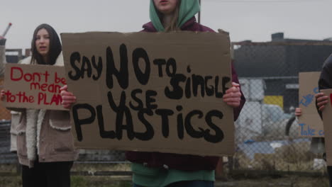 jovem segurando um cartaz de papelão contra o uso de plásticos durante um protesto contra as mudanças climáticas