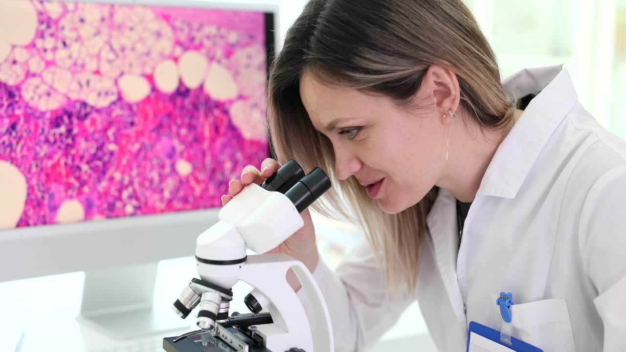 Scienziata che esamina campioni biologici al microscopio