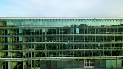 Aerial-trucking-shot-of-modern-mirrored-building-in-Gdynia,Poland---Pomeranian-Science-and-Technology-Park