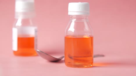 orange liquid medicine in bottles