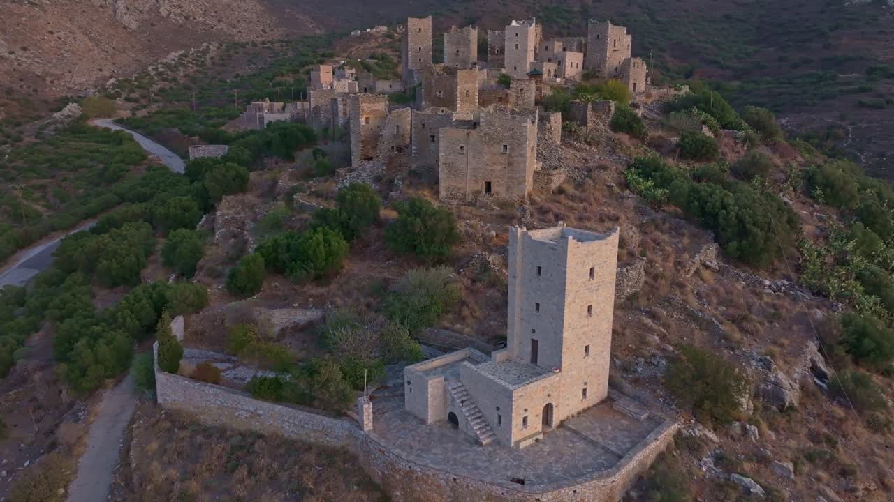 Prospettiva da drone di un borgo abbandonato in collina al tramonto, Vathia, Grecia