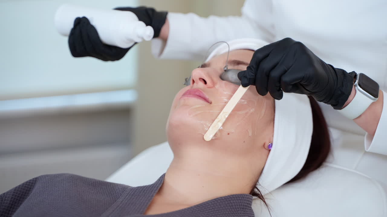 Kvinde modtager en ansigtsbehandling i en spa