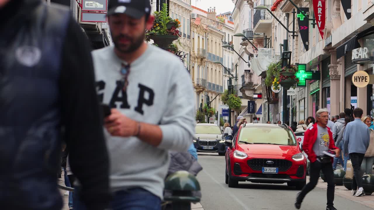 People On Sidewalks Of Famous Shopping Street Rue d’Antibes in Cannes, France. Static Shot