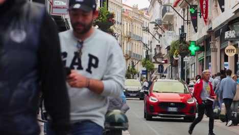 people on sidewalks of famous shopping street rue d’antibes in cannes, france. static shot