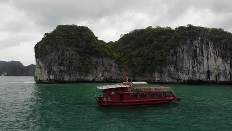 Ha-Long-Bay-Boat-Pasando-A-Través-De-Un-Disparo-De-Dron,-Panoramización-De-Drones-De-Derecha-A-Izquierda