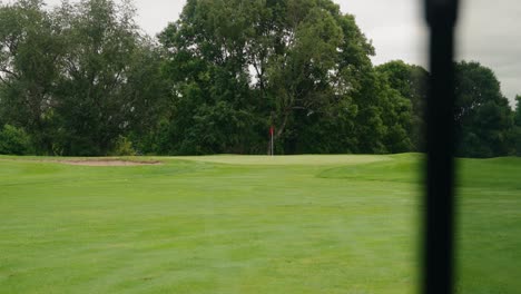 View-of-a-golf-hole-with-a-green-side-bunker-and-red-flag