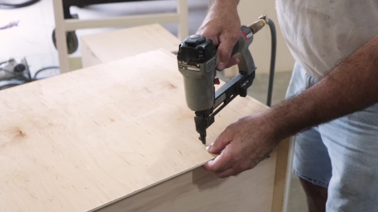 Man Nailing Cabinet Pieces Together