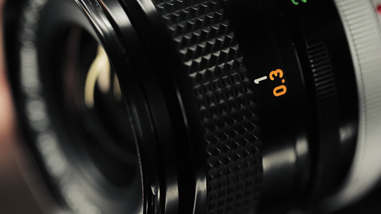 Vintage manual focus lens adjustment with engraved aperture and focus markings