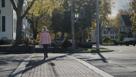 a child crosses the road on a pedestrian crossing in a small american town