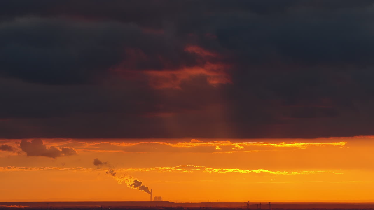 Aerial drone view of Belgrade with the silhouette of a distant industrial plant and smokestack emitting clouds of steam