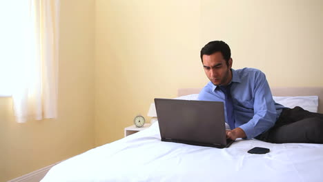 Alegre-Hombre-De-Negocios-Escribiendo-En-Su-Cuaderno-En-La-Cama