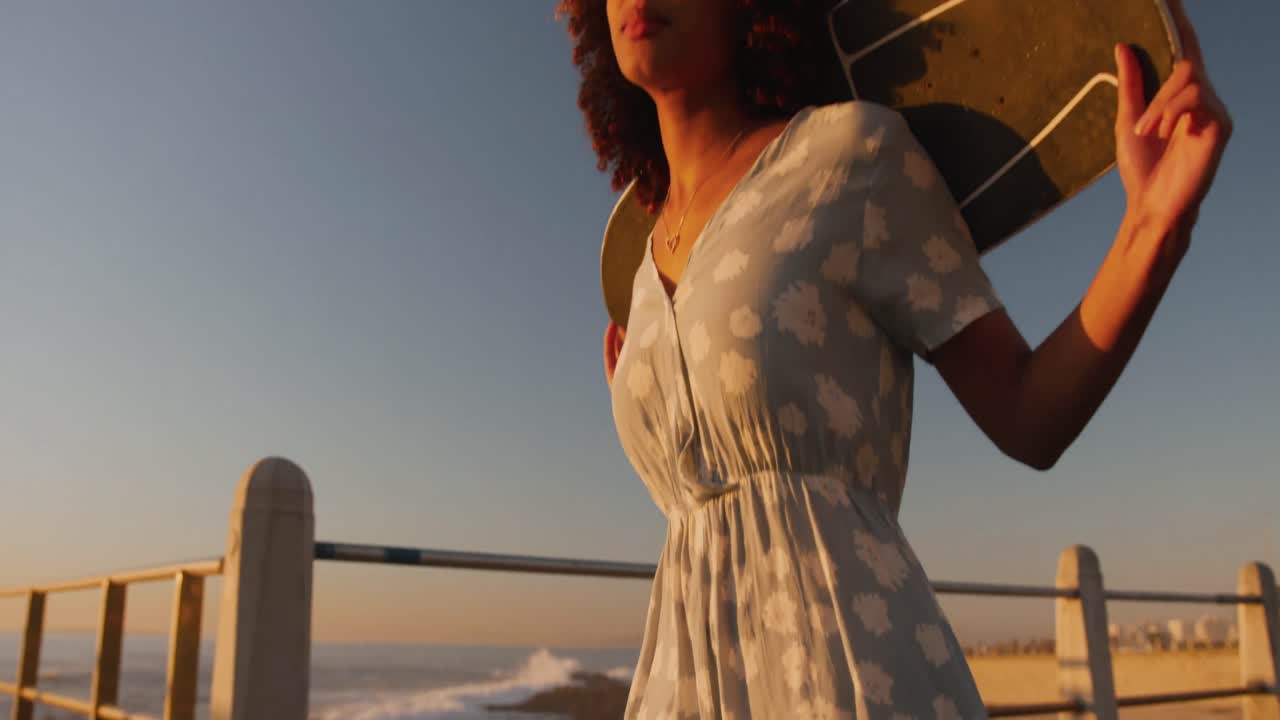 여자 가  ⁇ 고 손 에 스케이트 보드 를 들고 있다