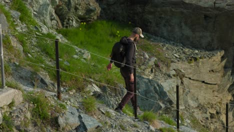 male backpacker walking downhill in valmalenco, sondrio, italy