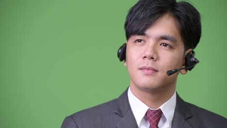 joven y guapo hombre de negocios asiático que trabaja como representante de un centro de llamadas