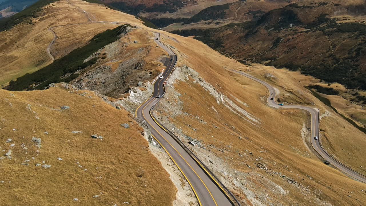Aerial drone view of nature in Romania. Carpathian mountains, sparse vegetation, Transalpina road with cars