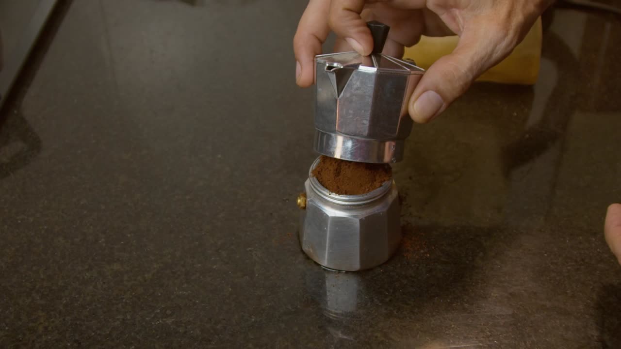 granos de café molidos en la cafetera moka que prepara café - toma de primer plano