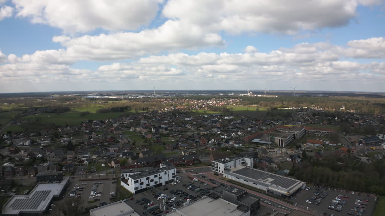 Belgium township with fluffy clouds above, aerial view