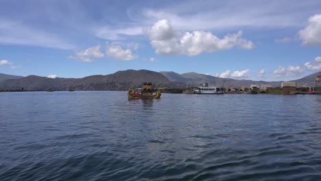 barco de totora navegando en el lago titicaca frente a las islas flotantes de los uros en puno, perú