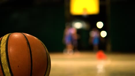 Baloncesto-En-El-Suelo-Mientras-Los-Jugadores-Están-En-El-Fondo