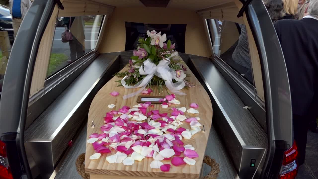 closeup shot of a funeral casket in a hearse or chapel or burial at cemetery