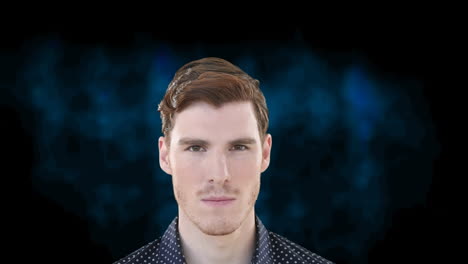 portrait of caucasian man looking to camera and breaking into smile, on dark blue background