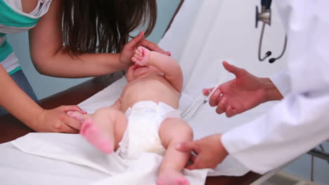 Mother-and-female-doctor-doing-an-injection-on-a-cryingbaby