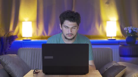 hombre mirando cansado y agotado en la computadora portátil por la noche.