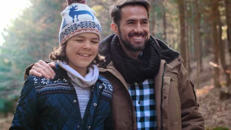 Happy-dad-and-teenage-son-walking-in-the-autumn-forest