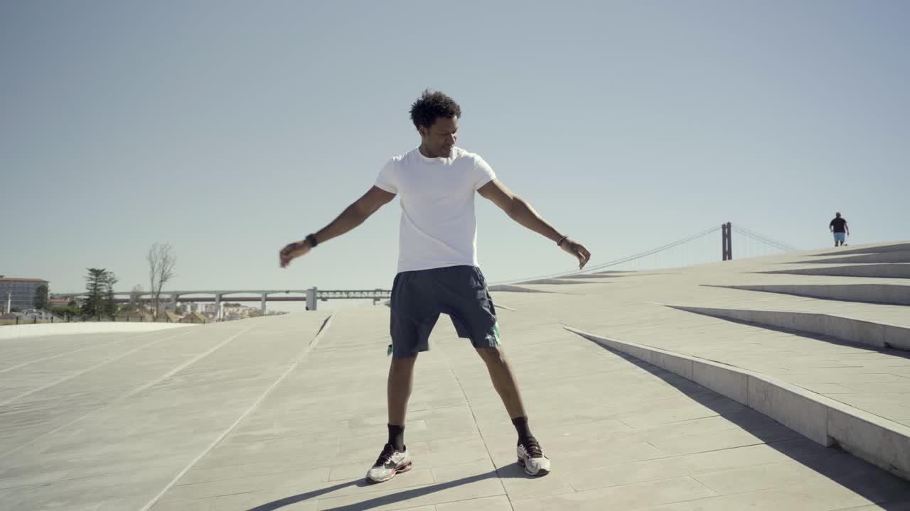 Smiling African American man stretching before training.