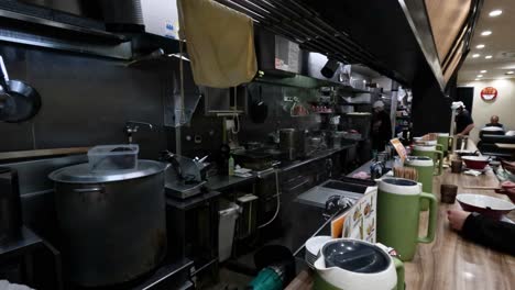 chefs preparing ramen in a bustling kitchen