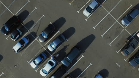 Drone-footage-people-walking-around-parking-place.-Drone-flying-over-parking