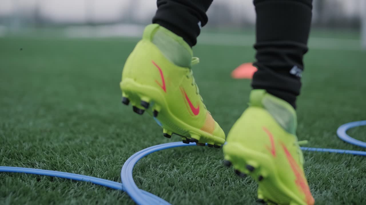 Una squadra di calcio per bambini si allena allo stadio sotto la guida di un allenatore. I bambini in divisa sportiva praticano esercizi con la palla, migliorano la tecnica e sviluppano il lavoro di squadra sul campo verde