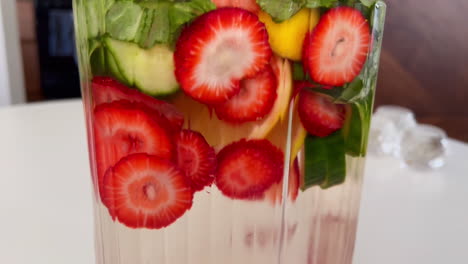 close up on spa water on a hot day, glass carafe of fruit and herb infused water