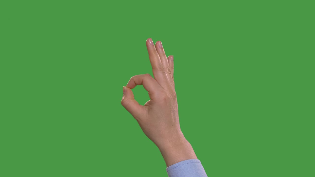 частичный вид женщины, показывающей знак "ок", зелёный экран с клавишей