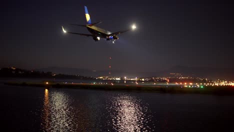 kerkyra, greece - october 28, 2021: close up footage of passenger plane landing above night sea, lights and dark