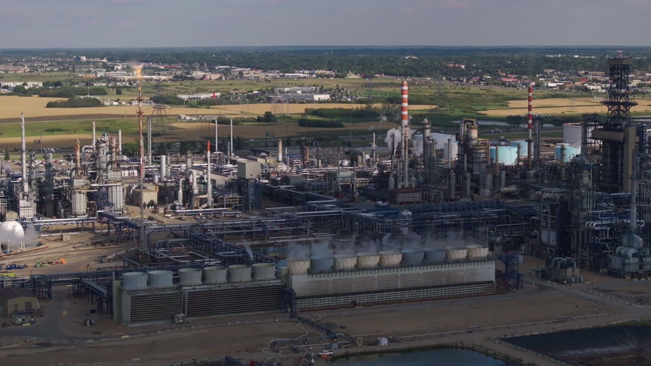 Aerial view of industrial complex with smokestacks and green fields nearby