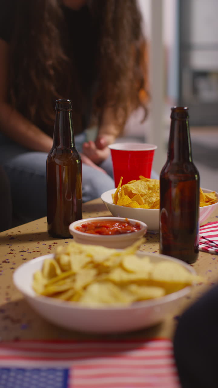 video vertical de amigos bebiendo cerveza y comiendo bocadillos en una fiesta que celebra el día de la independencia de estados unidos el 4 de julio