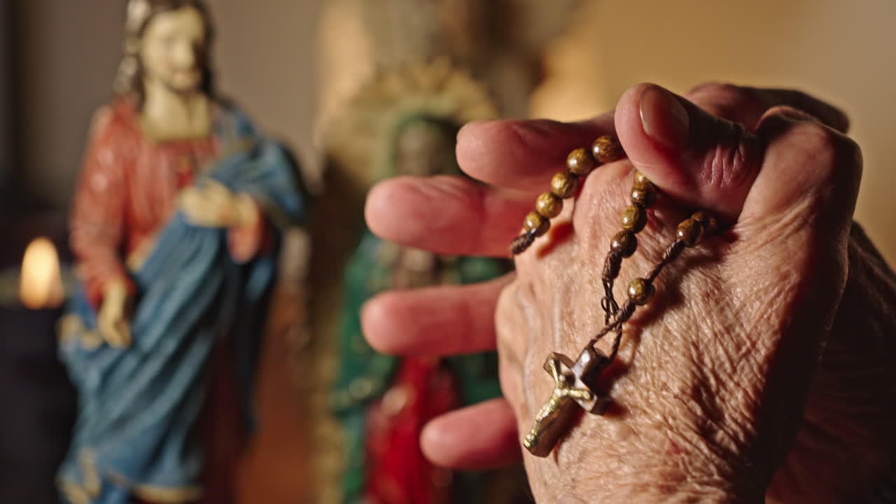 Elderly Person's Hands Holding a Rosary During Prayer