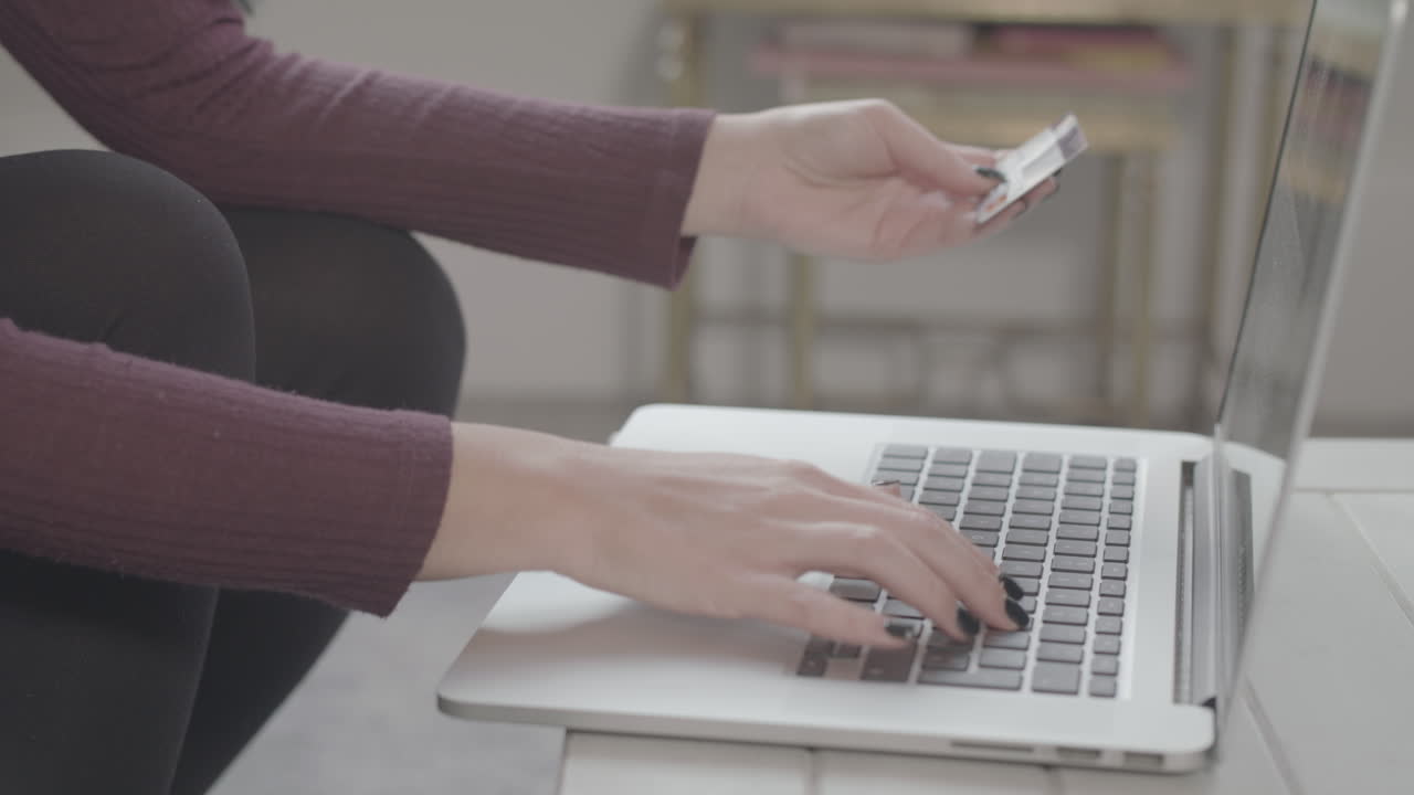 крупный план молодой женщины, вводящей данные кредитной карты в ноутбук для совершения покупки в интернете - без оценки