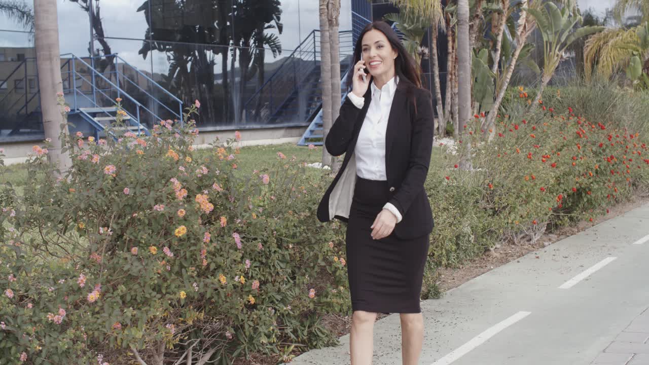 Busy young businesswoman walking along a street