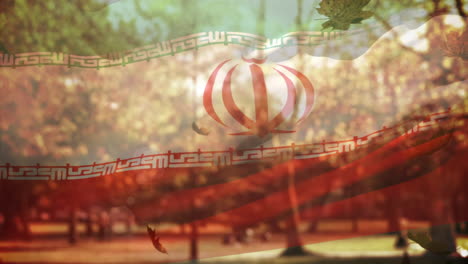 digital composition of iran waving flag over multiple autumn leaves falling against park