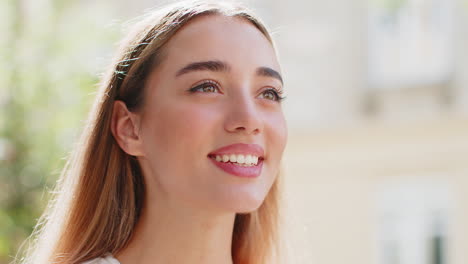 closeup portrait of happy woman face smiling open eyes glad expression looking away dreaming