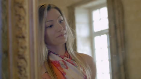 Luxury-changing-room---young-woman-trying-bohemian-blouse-in-front-of-mirror