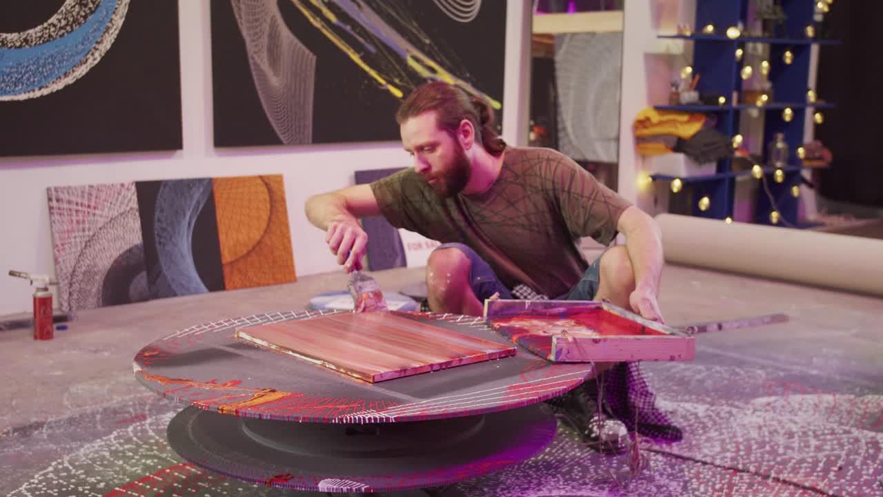 un hombre está sentado y pintando un cuadro