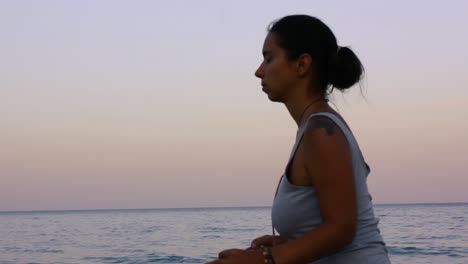 woman meditating at the beach