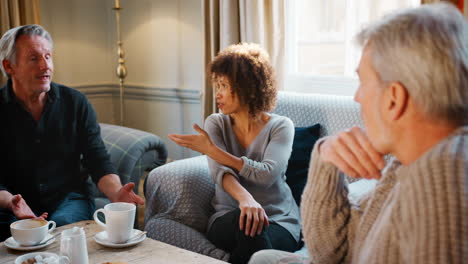 pull focus shot of middle aged friends meeting in coffee shop