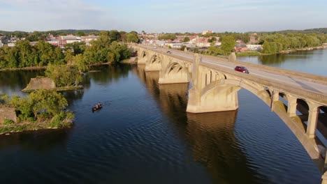 toma aérea inversa de drones del tráfico que atraviesa el puente sobre el río susquehanna, pescadores en bote