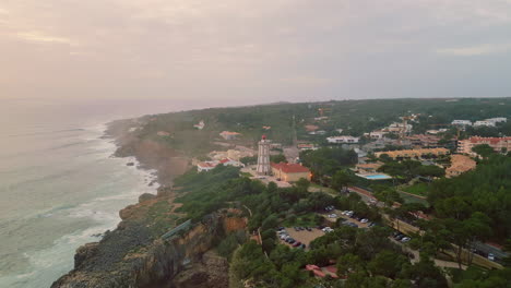 dusky sky rough coast washed by powerful ocean aerial view. modern lighthouse