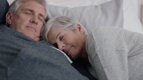 happy mature couple lying in bed cuddleing together resting feeling tired enjoying relaxing comfortable at home peaceful retirement 4k footage